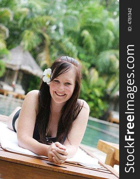 Woman in bikini relaxing on a deck chair.