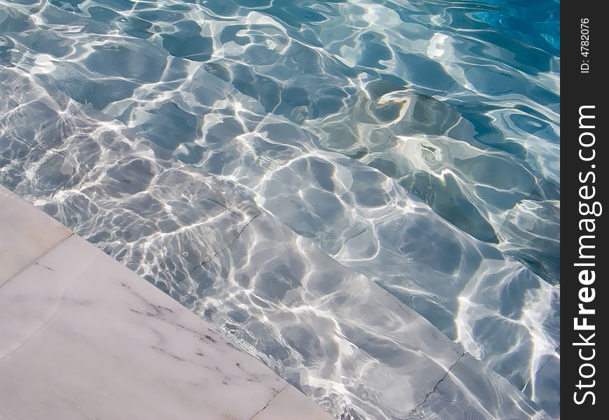 Abstract background with blue water and stairs of the swimming pool