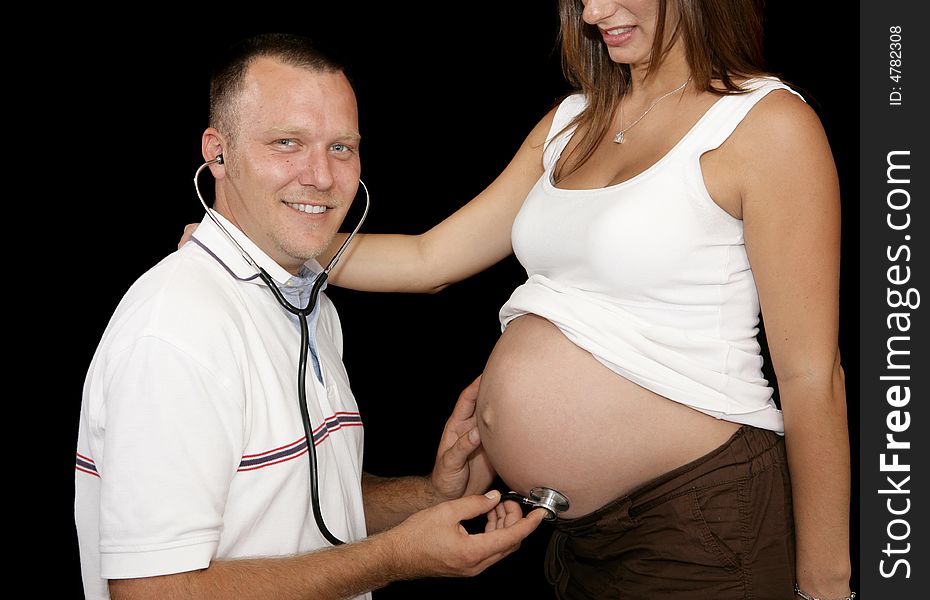 Happy expectant father listening to his wife's pregnant belly with a stethoscope. Happy expectant father listening to his wife's pregnant belly with a stethoscope.