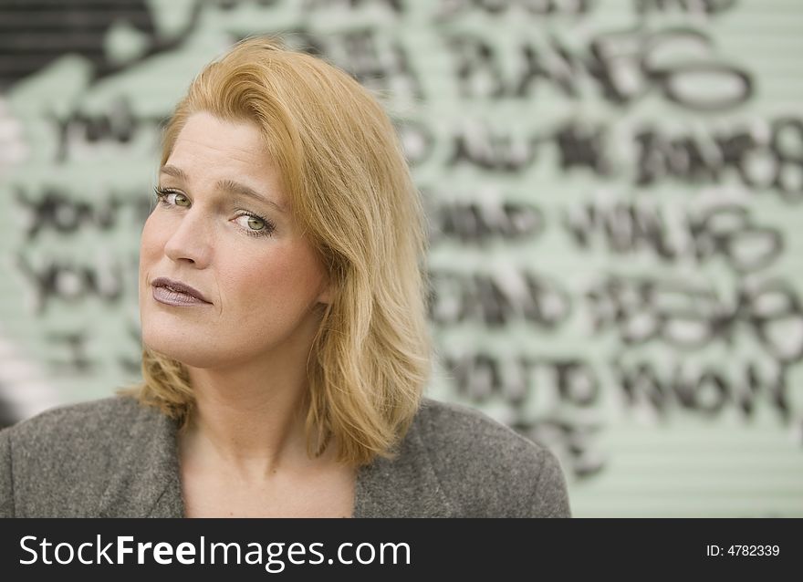 Portrait of a blonde woman in front of graffiti
