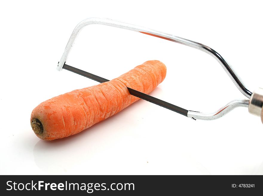 A carrot with a metal saw on white background. A carrot with a metal saw on white background