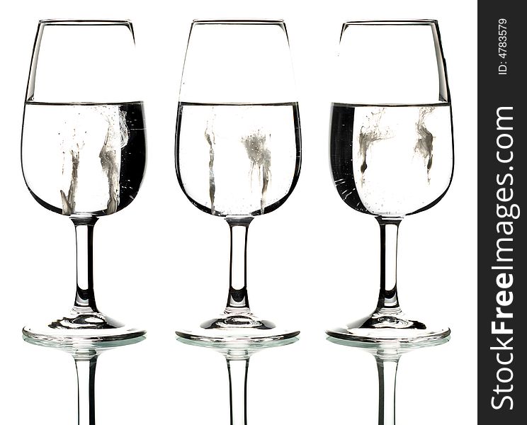 Silhouette of three glasses containing a creamy splatter