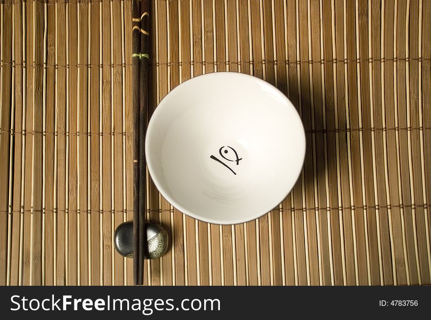 Japanese or chinese place-mat with white bowl and sticks. Japanese or chinese place-mat with white bowl and sticks