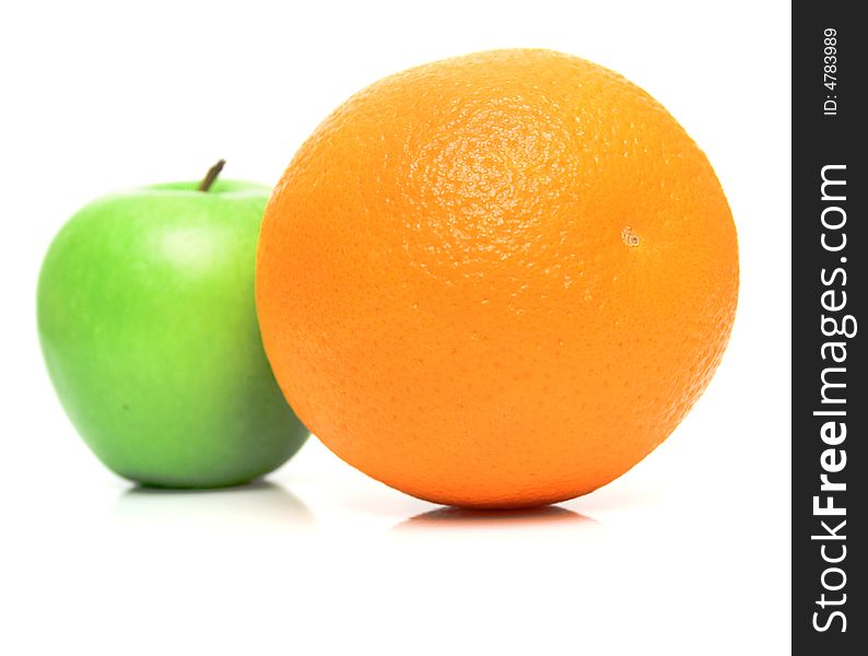 The ripe juicy apple covered by drops of water. Behind of a orange the green apple. Isolation on white, shallow DOF. The ripe juicy apple covered by drops of water. Behind of a orange the green apple. Isolation on white, shallow DOF.