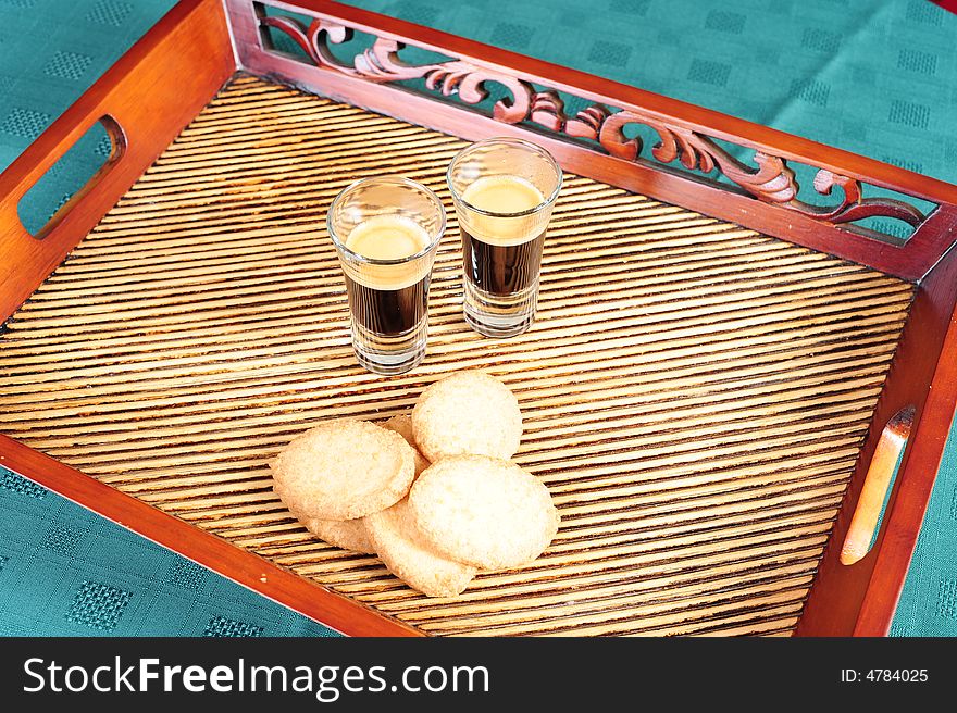 Freshly brewed espresso shot in a tray, with some cookies.  Shot taken from the top. Freshly brewed espresso shot in a tray, with some cookies.  Shot taken from the top.