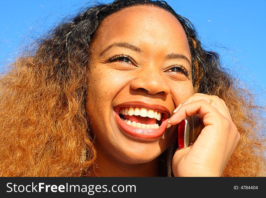 Woman expressing happiness while talking on the phone. Woman expressing happiness while talking on the phone.