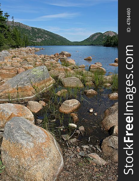 Portrait landscape shot of rocks on the shore of Bubble Pond in Acadia, Maine. Portrait landscape shot of rocks on the shore of Bubble Pond in Acadia, Maine.