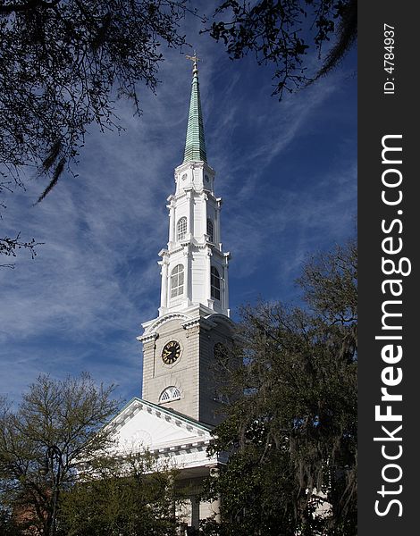 A white church steeple against a vivid blue sky