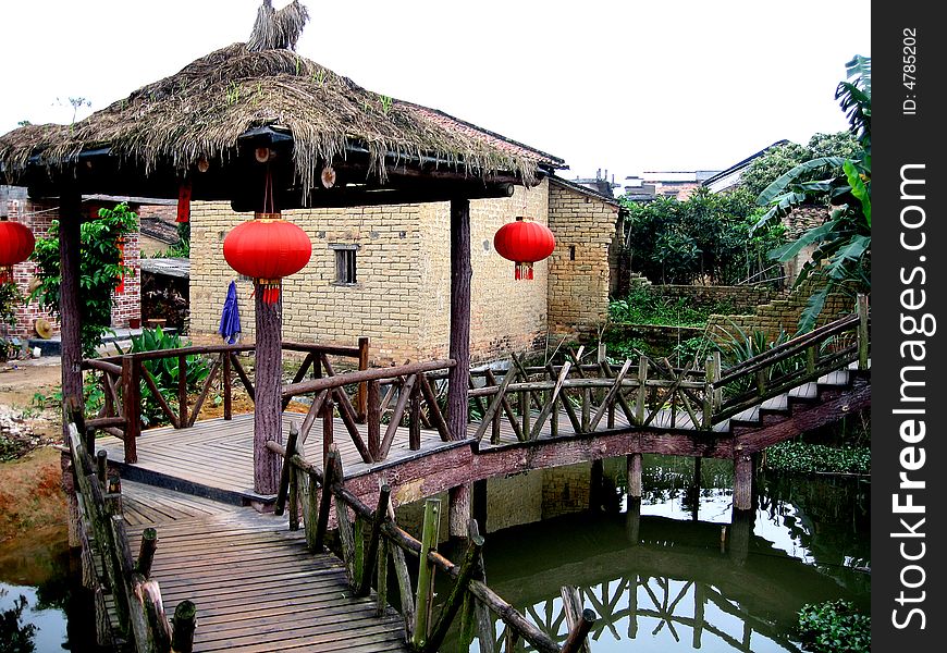 Water country view in Canton,China.The thatched wood pavilion,wood corridor over water and antique earth houses.