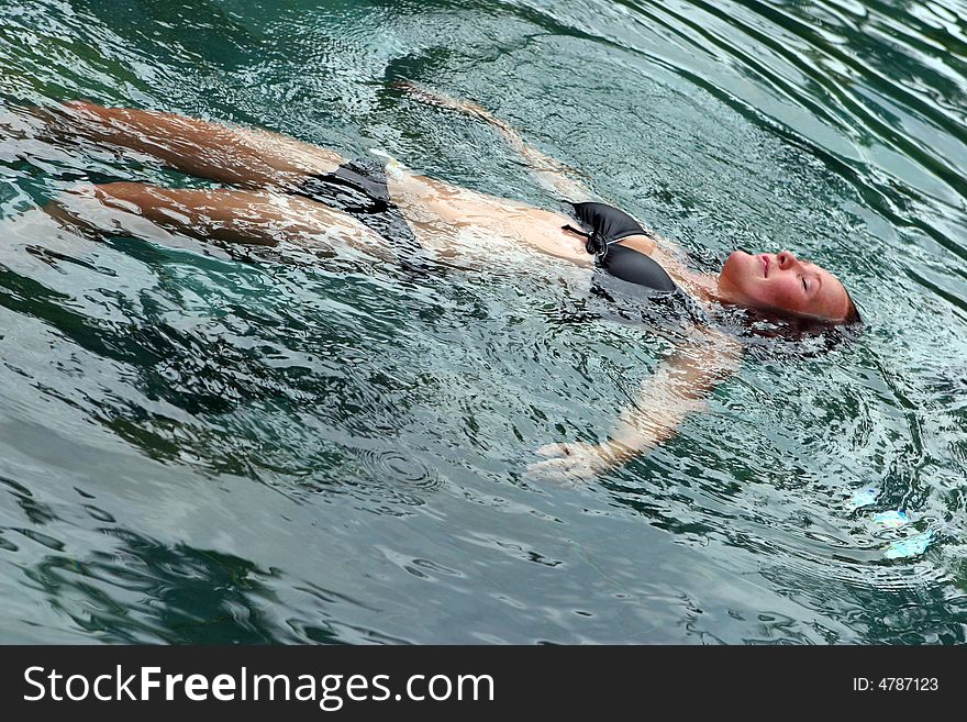 Woman floating in the water with her eyes closed. Woman floating in the water with her eyes closed.