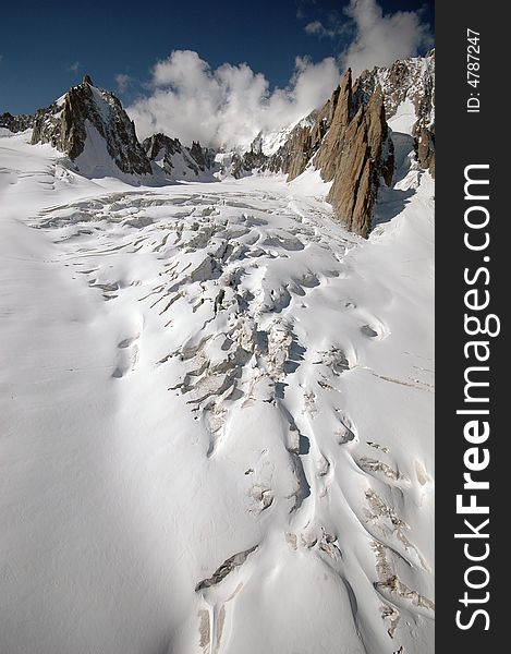 Glacier with crevasses and distant mountains in French Alps. Glacier with crevasses and distant mountains in French Alps