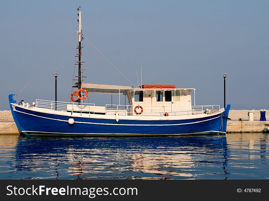 Blue greek fishing boat in sunset light. Blue greek fishing boat in sunset light