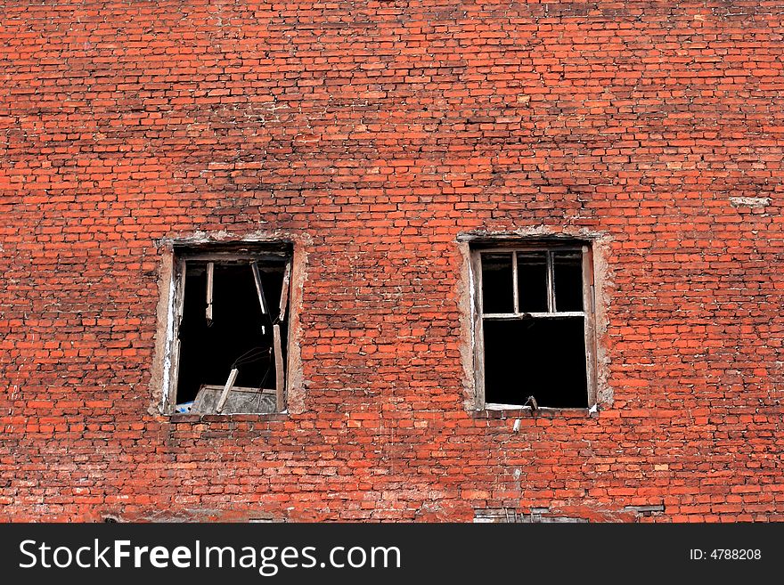 Old urban brick wall with destroyed windows