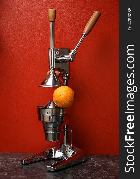 Juicy orange and a manual (mechanical) squezeer. Juicy orange and a manual (mechanical) squezeer