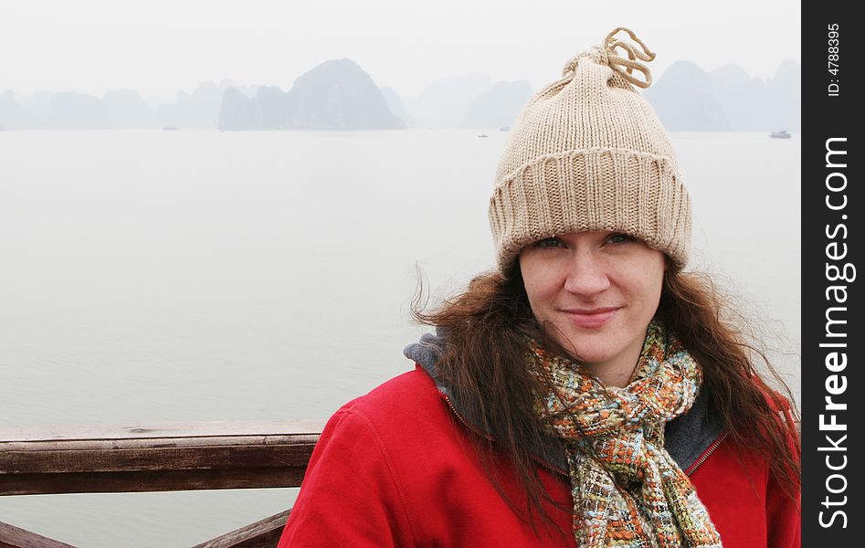 Woman on the deck of a boat dressed in winter clothing.