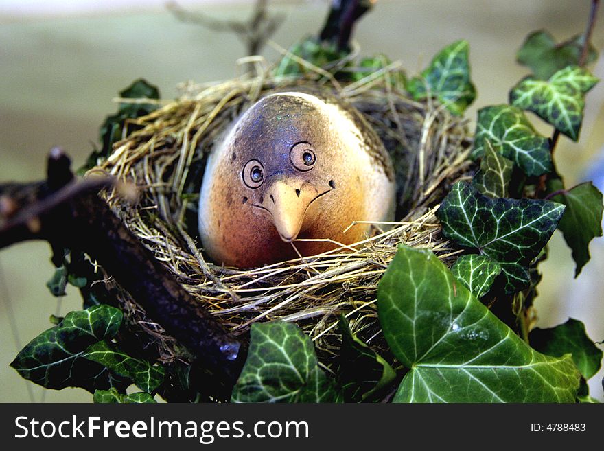 Ceramic bird in a stylized nest. Ceramic bird in a stylized nest