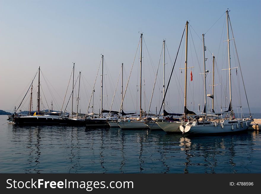 Modern yachts in shipyard on sunset