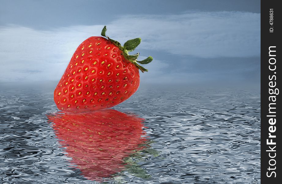 Isolated strawberry on water with reflections and cloudy sky