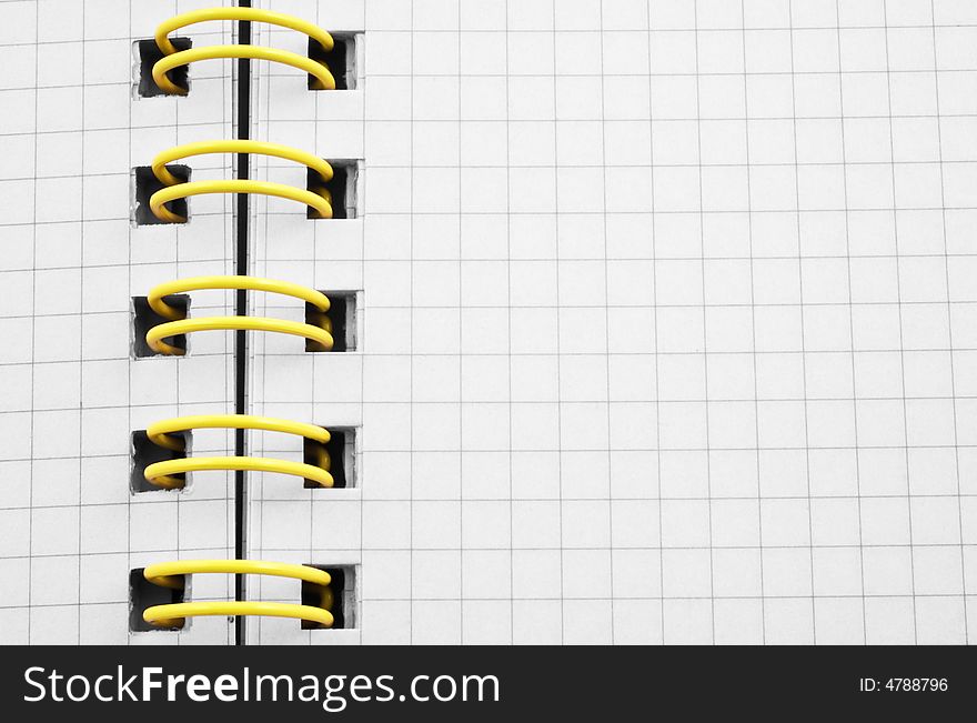 Close up of a spiral bound notebook with yellow spirals