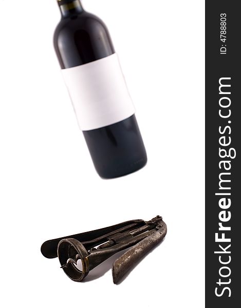 Wine bottle and corkscrew isolated on white with selective focus