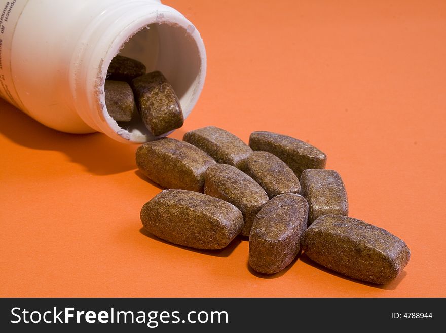 Jar with pills on an orange background