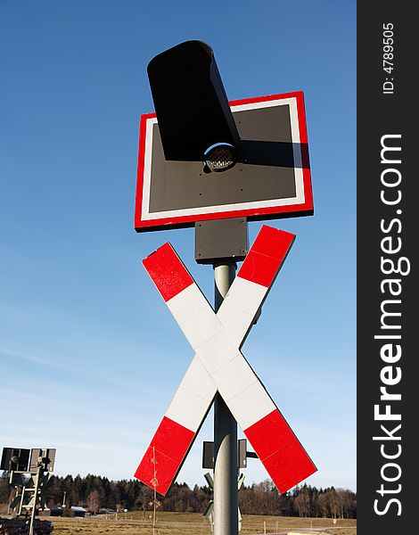 Railroad crossing sign vertical against blue sky