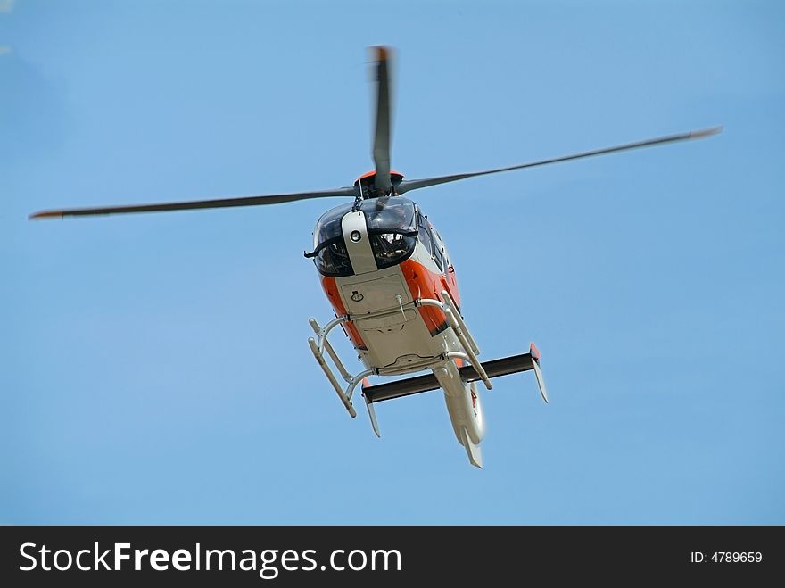 Orange and gray coloured helicopter landing