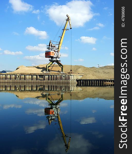 Crane with bucket and reflection in water. Crane with bucket and reflection in water