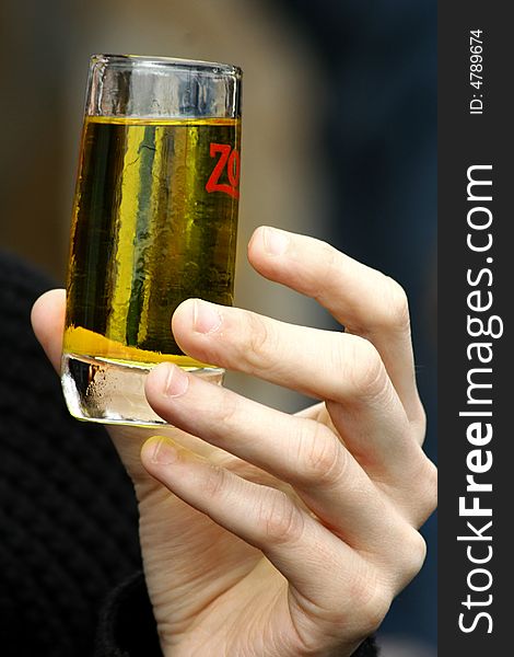 An image aof a hand taking a glass with a green drink. An image aof a hand taking a glass with a green drink