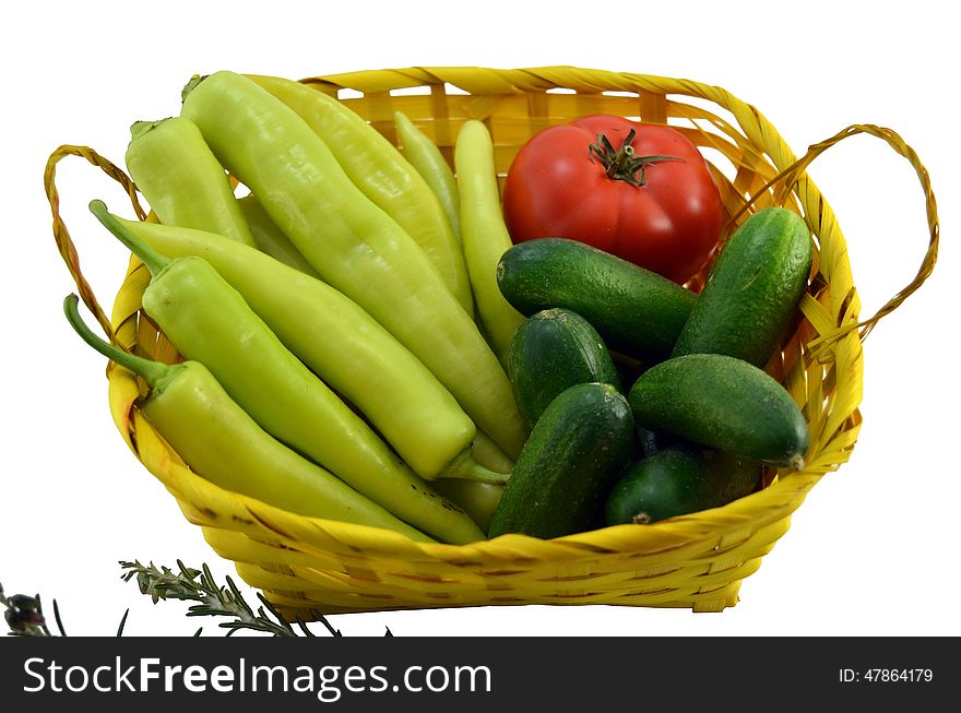 Green peppers, tomato and cucumbers in a basket isolated on white background. Green peppers, tomato and cucumbers in a basket isolated on white background