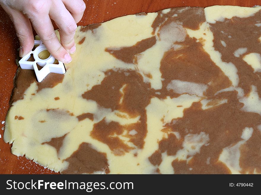 Spotty dough and star shape in hand, food background