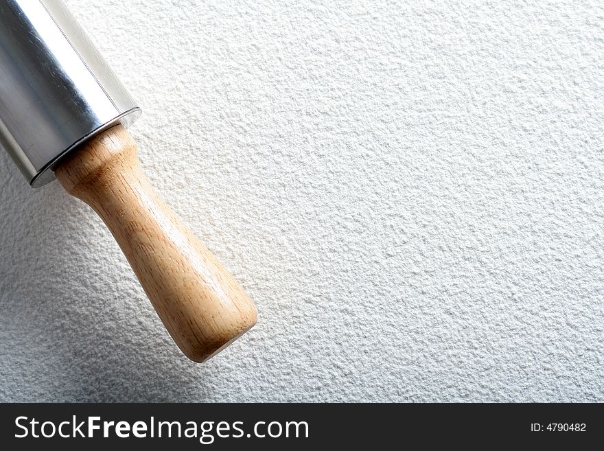 Rolling pin on wheat flour, background
