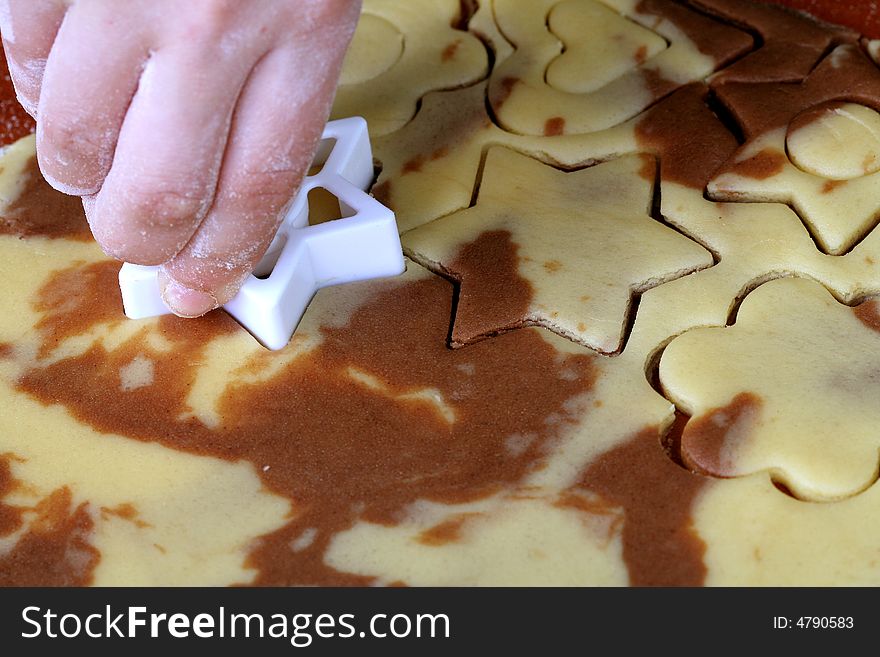 Spotty dough and star shape in hand, food background