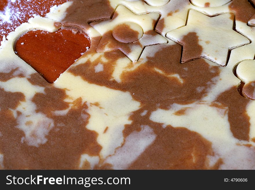 Various figures on spotty chocolate dough, food background