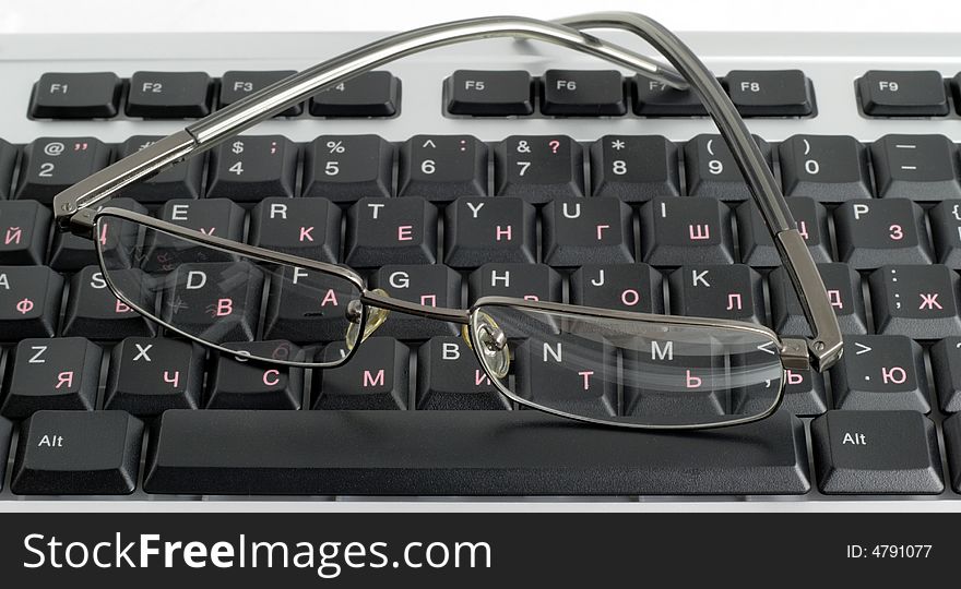 The computer keyboard and glasses