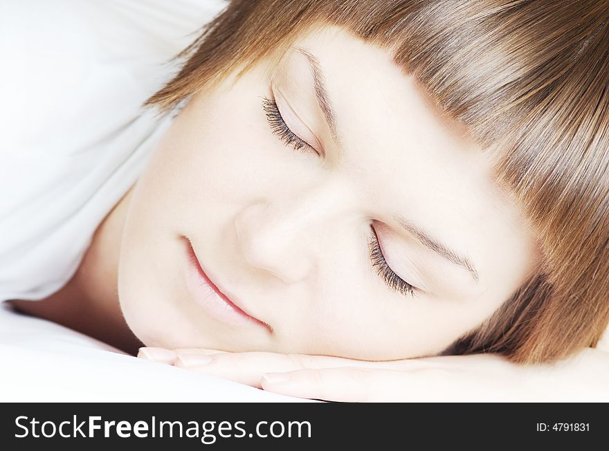 Beautiful woman in white sleeping close up, in hi key, horizontal