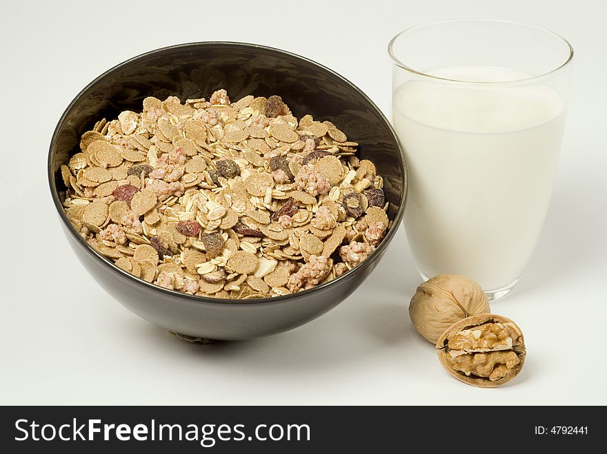 Bowl with cereals, a glass of milk and walnuts. Bowl with cereals, a glass of milk and walnuts