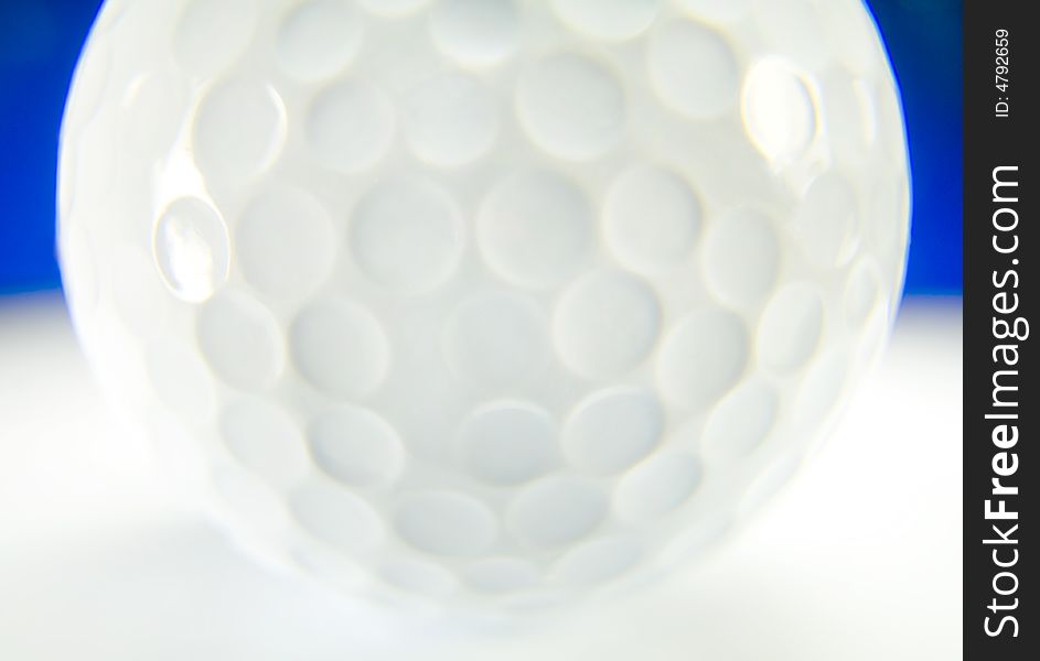 Close-up from a golfball on white with blue background