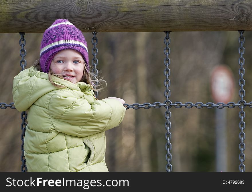 Little girl climbing on chains. Little girl climbing on chains