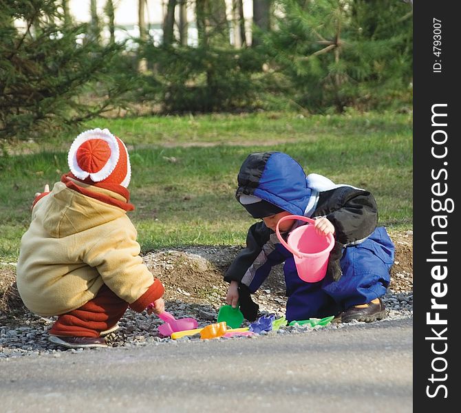 Small girl and the boy play color toys at road (1)