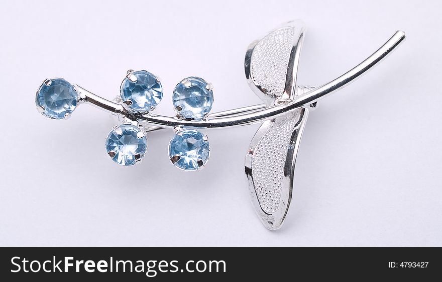 Silver broach with blue gems on white background. Silver broach with blue gems on white background