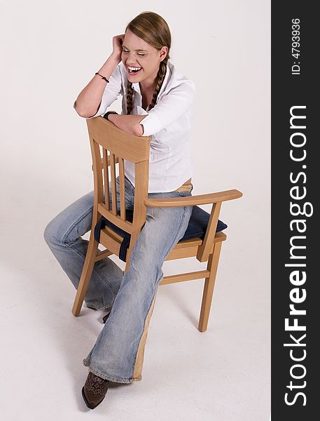 Laughing girl sitting on a chair. Laughing girl sitting on a chair