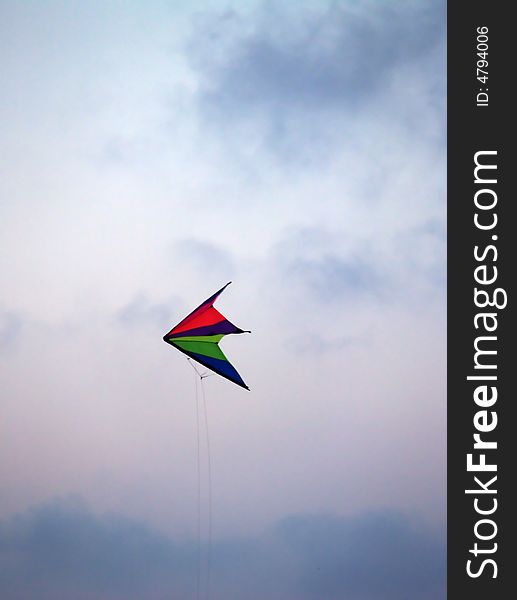 A colourful kite in a stormy sky. A colourful kite in a stormy sky