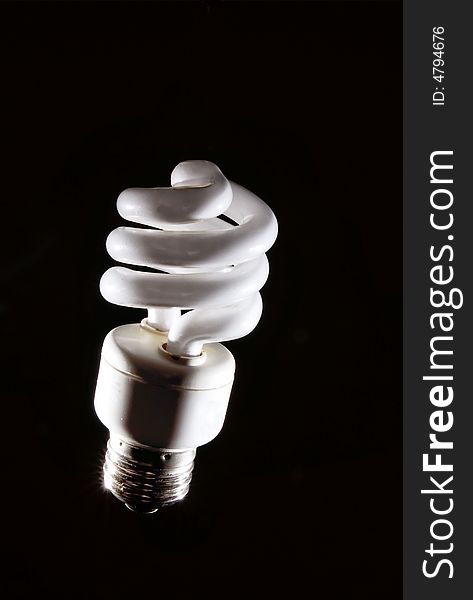 Cfl fluorescent lightbulb on dark background. Cfl fluorescent lightbulb on dark background
