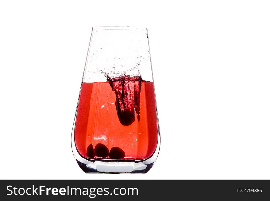 A crystal vase filled with four cherries and its juice. A crystal vase filled with four cherries and its juice