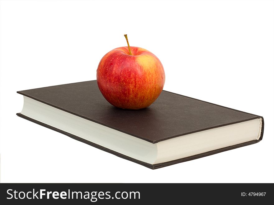 Red apple on a black book, isolated over white background. Red apple on a black book, isolated over white background