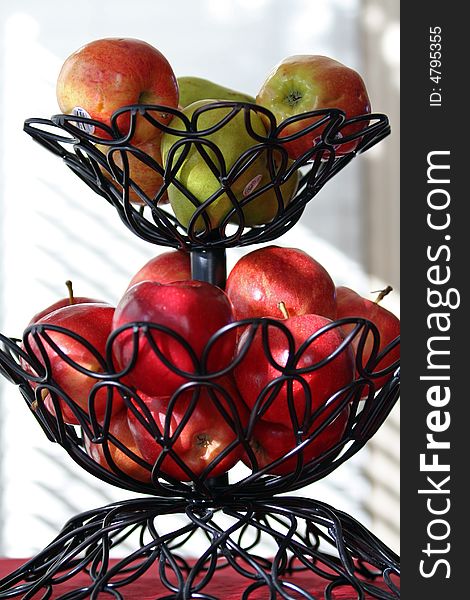 Apples in a basket on a table with natural sun light. Apples in a basket on a table with natural sun light.