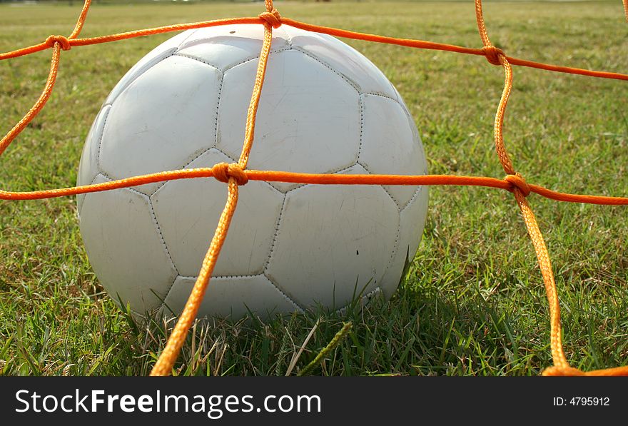 A close up shot of a soccer ball in the back of the net