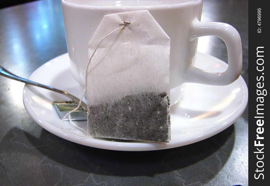 Packet of tea beside white ceramic cup