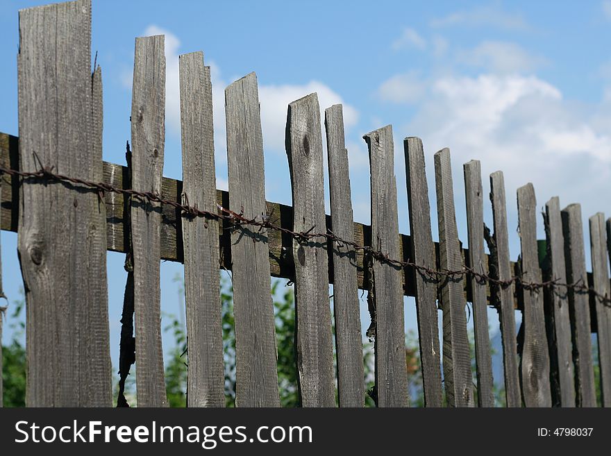 Old Wood Fence over a blue sky with clouds